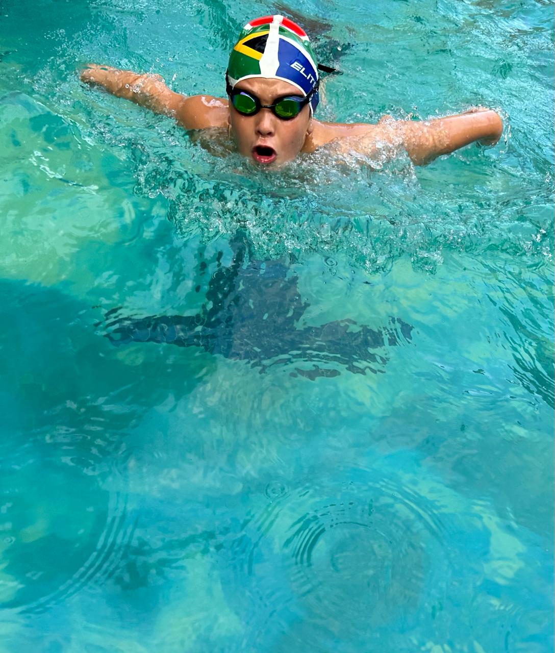 boy with swimming goggles and swimming cap diving at splashmates swim school